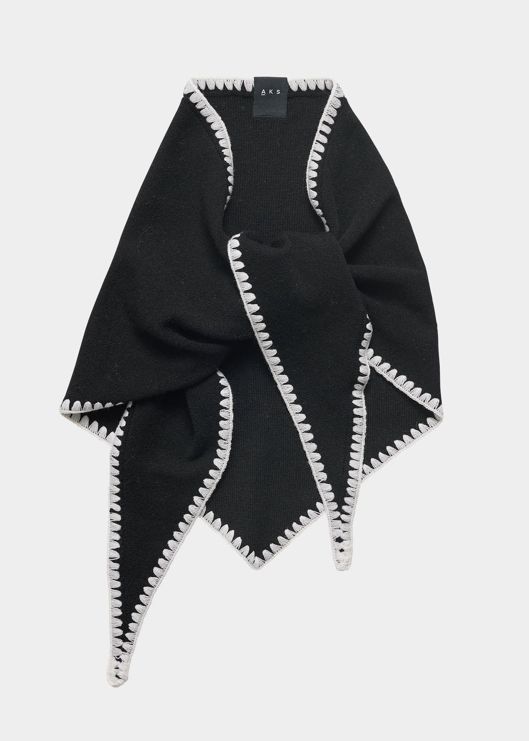 Black poncho with white trim on a light gray background